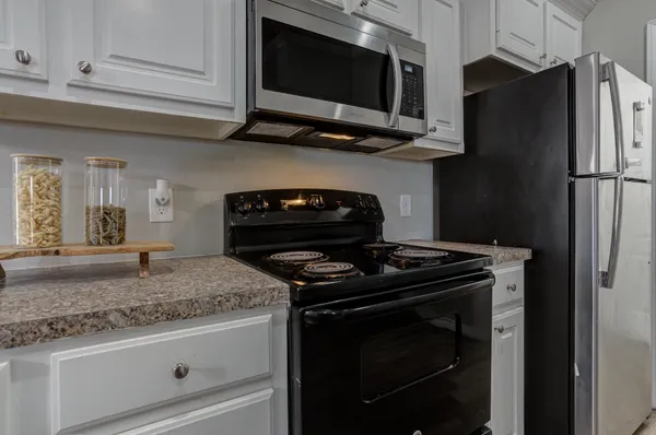 a kitchen with stainless steel appliances granite countertop a stove and a microwave