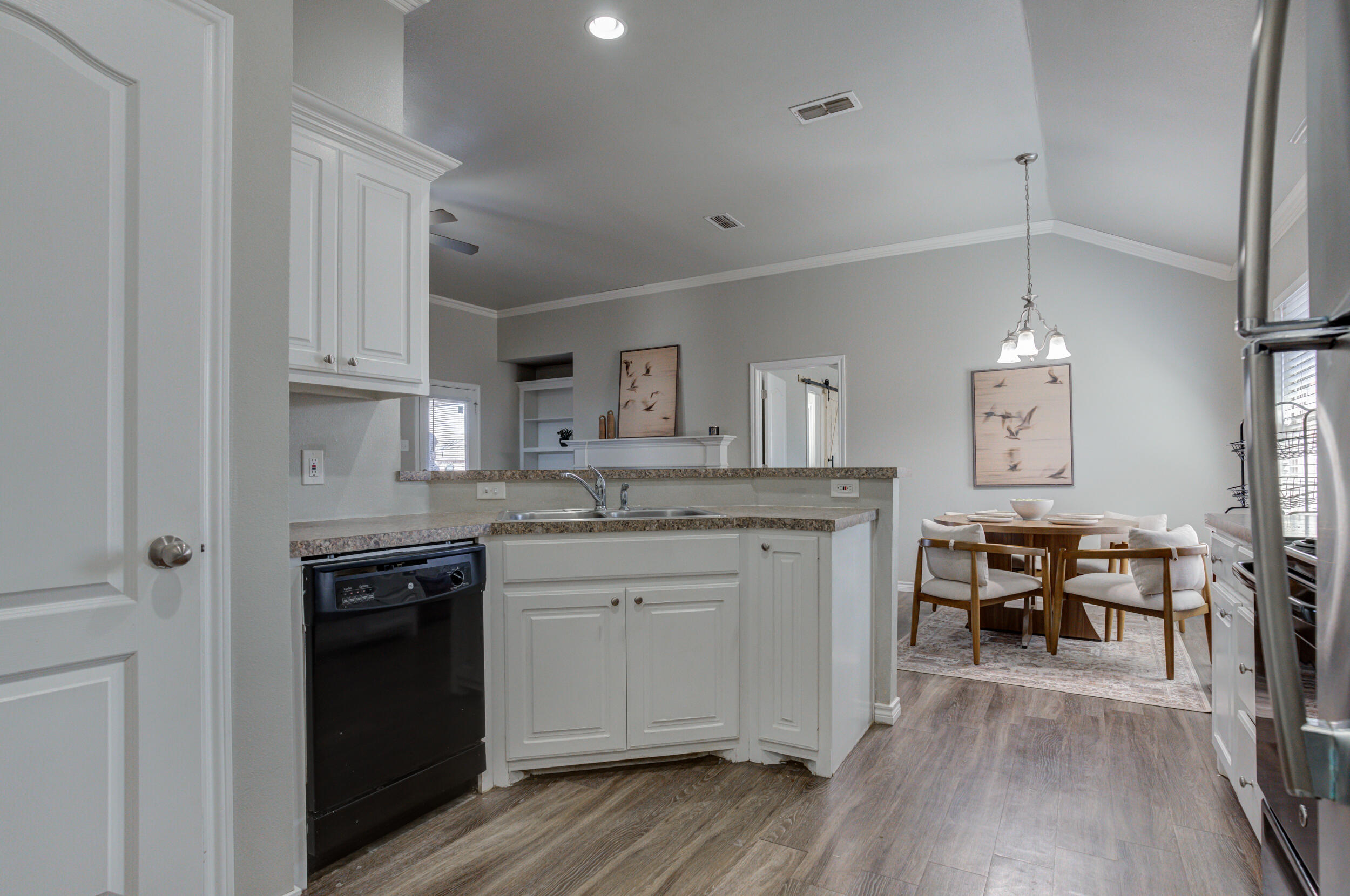 2022 88th Street Lubbock, TX 79423 - Photo 13 of 33 a kitchen with kitchen island granite countertop a sink cabinets and wooden floor