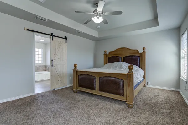 a bedroom with a bed and a ceiling fan