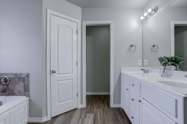 a en suite bathroom with a sink double vanity and a mirror