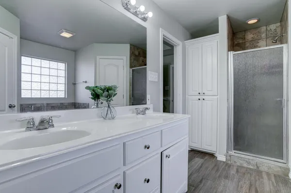 a bathroom with a double vanity sink and mirror