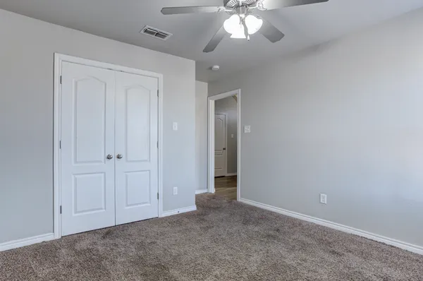 an empty room with a chandelier fan