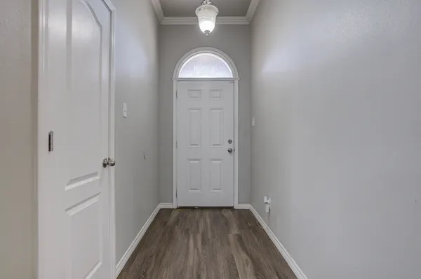 a view of a hallway with wooden floor and a mirror