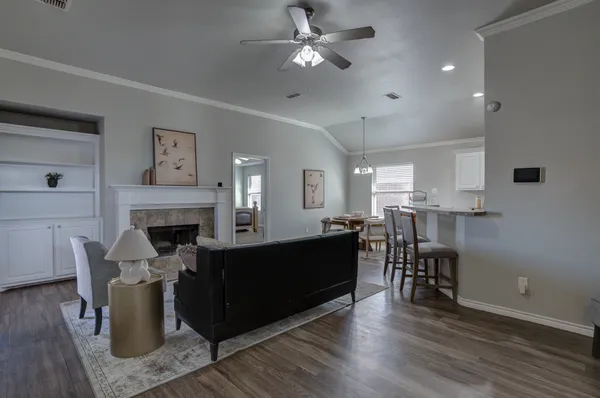 a living room with furniture a fireplace and a ceiling fan