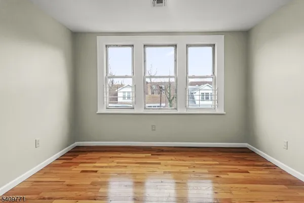 a view of a room with wooden floor and a window
