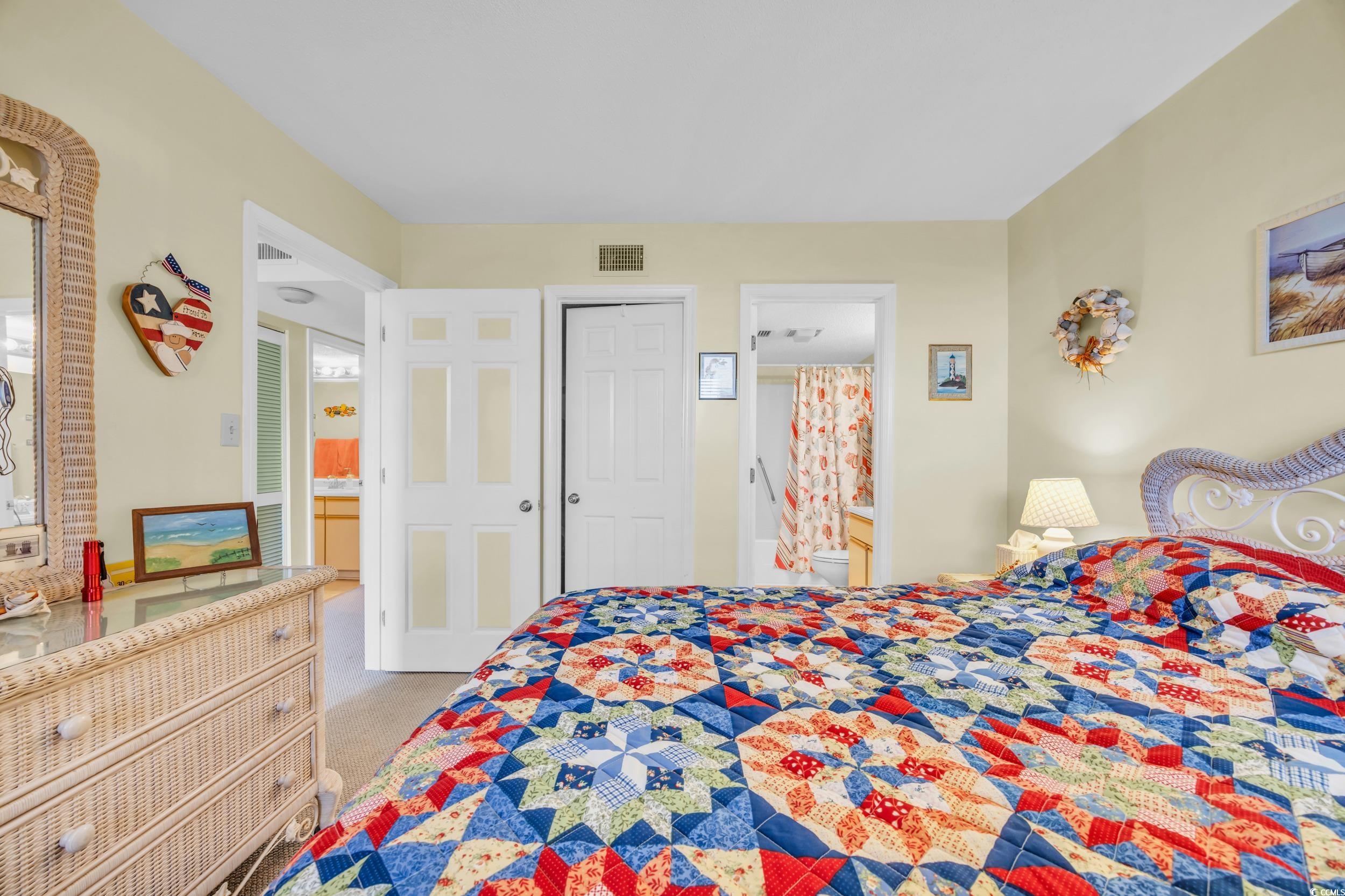 310 73rd Avenue North, Unit 5C Myrtle Beach, SC 29572 - Photo 11 of 20 Bedroom featuring connected bathroom, light carpet, and a closet