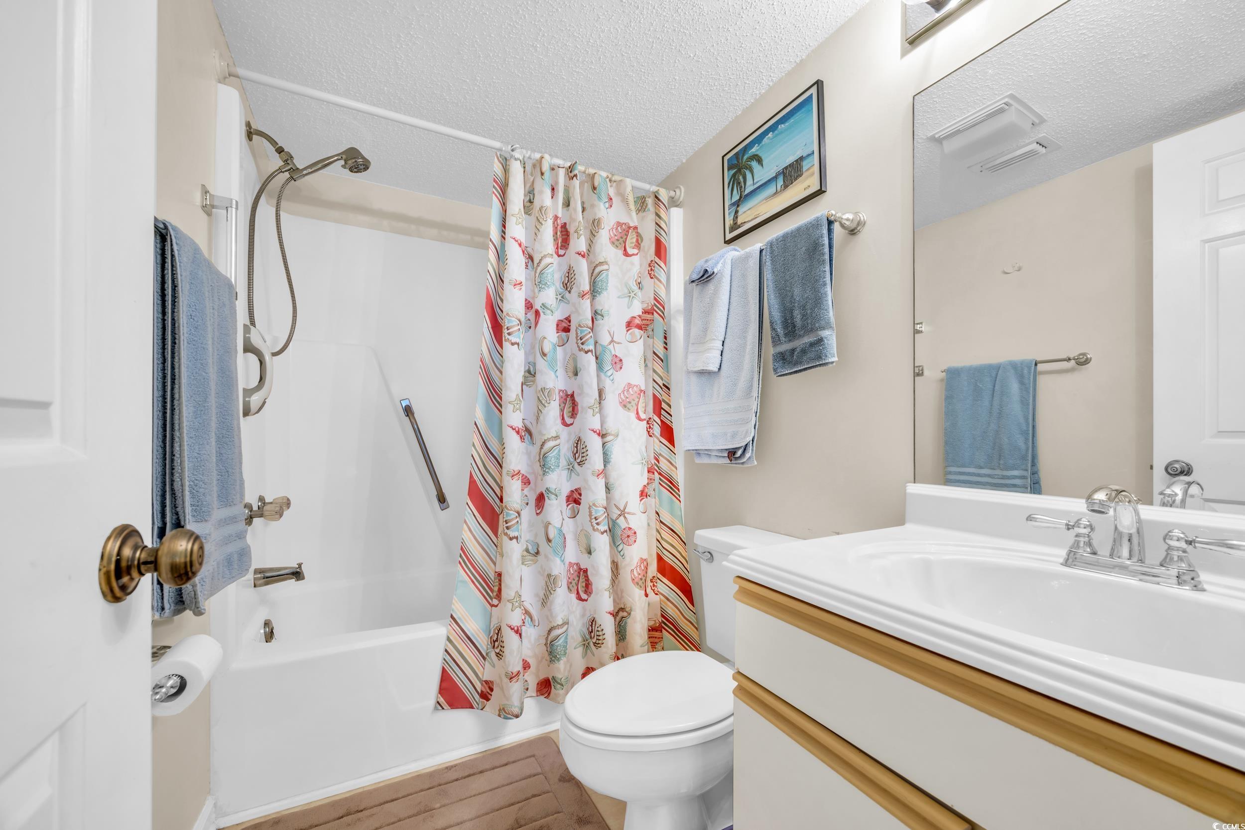 310 73rd Avenue North, Unit 5C Myrtle Beach, SC 29572 - Photo 12 of 20 Full bath featuring shower / bathtub combination with curtain, vanity, a textured ceiling, and wood finished floors
