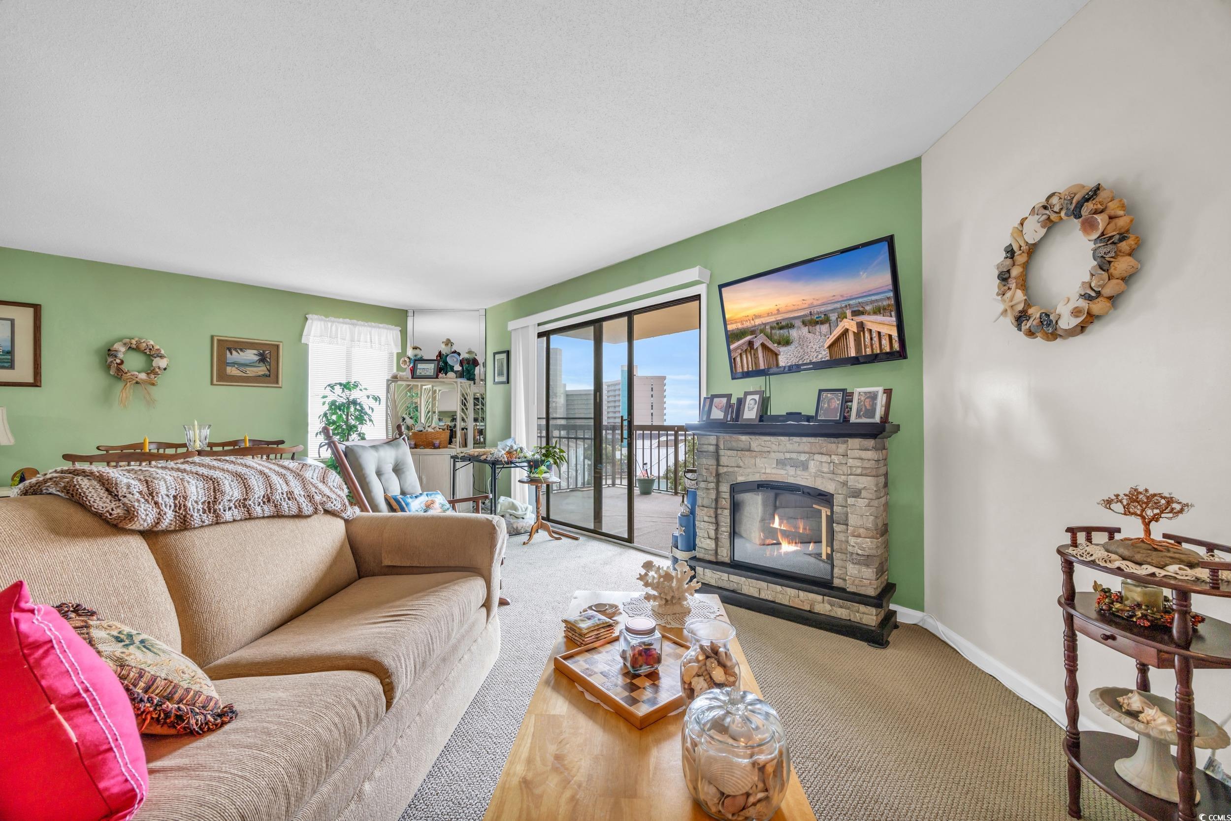 310 73rd Avenue North, Unit 5C Myrtle Beach, SC 29572 - Photo 6 of 20 Living area featuring carpet flooring and a stone fireplace