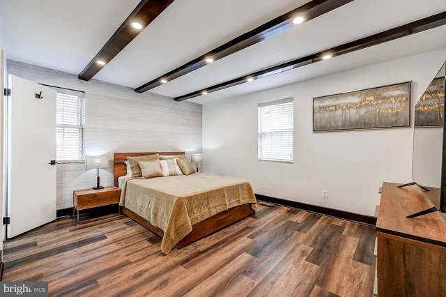a bedroom with a bed and wooden floor