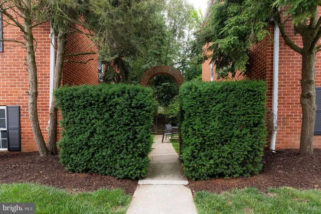 a pathway of a house with lots of green space