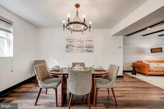a dining room with furniture a chandelier and wooden floor