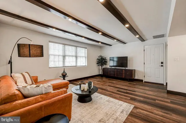 a living room with furniture wooden floor and a window