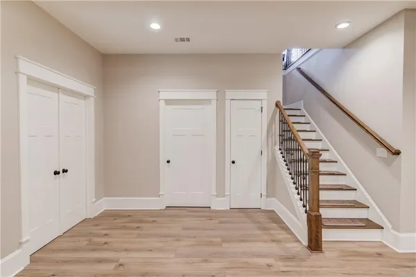 an empty room with wooden floor and ceiling fan