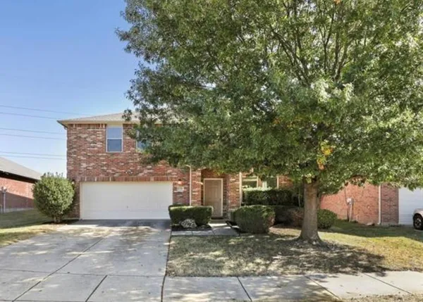 a view of a house with a tree and plants