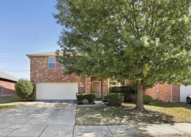 a view of a house with a tree and plants