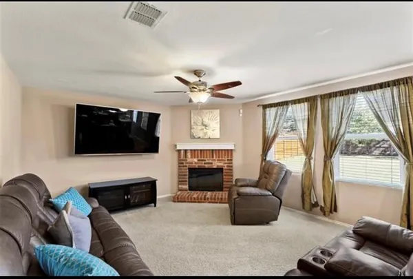 a living room with furniture a fireplace and a flat screen tv