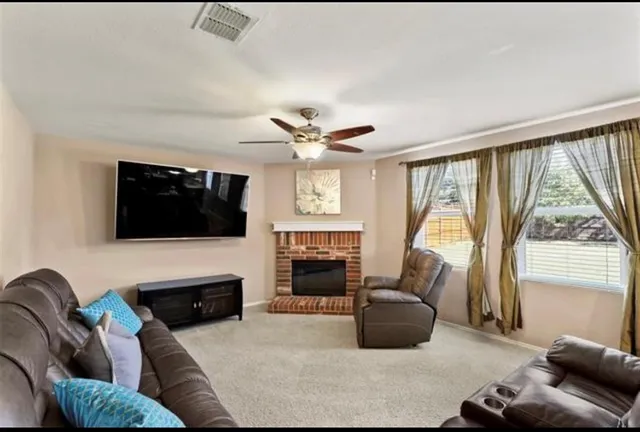 a living room with furniture a fireplace and a flat screen tv