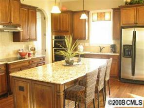 2031 Fallondale Road Waxhaw, NC 28173 - Photo 3 of 4 a kitchen with stainless steel appliances granite countertop a table chairs and a refrigerator