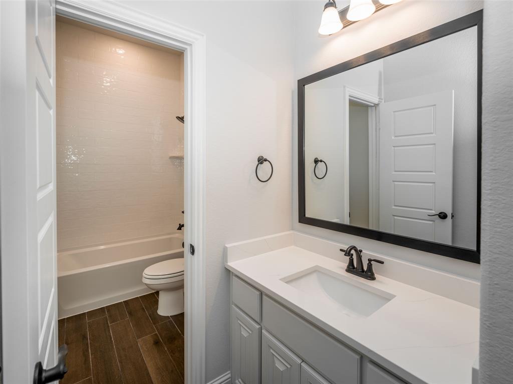2108 Charters Circle Nevada, TX 75173 - Photo 25 of 37 Bathroom featuring vanity, wood finish floors, and shower / tub combination