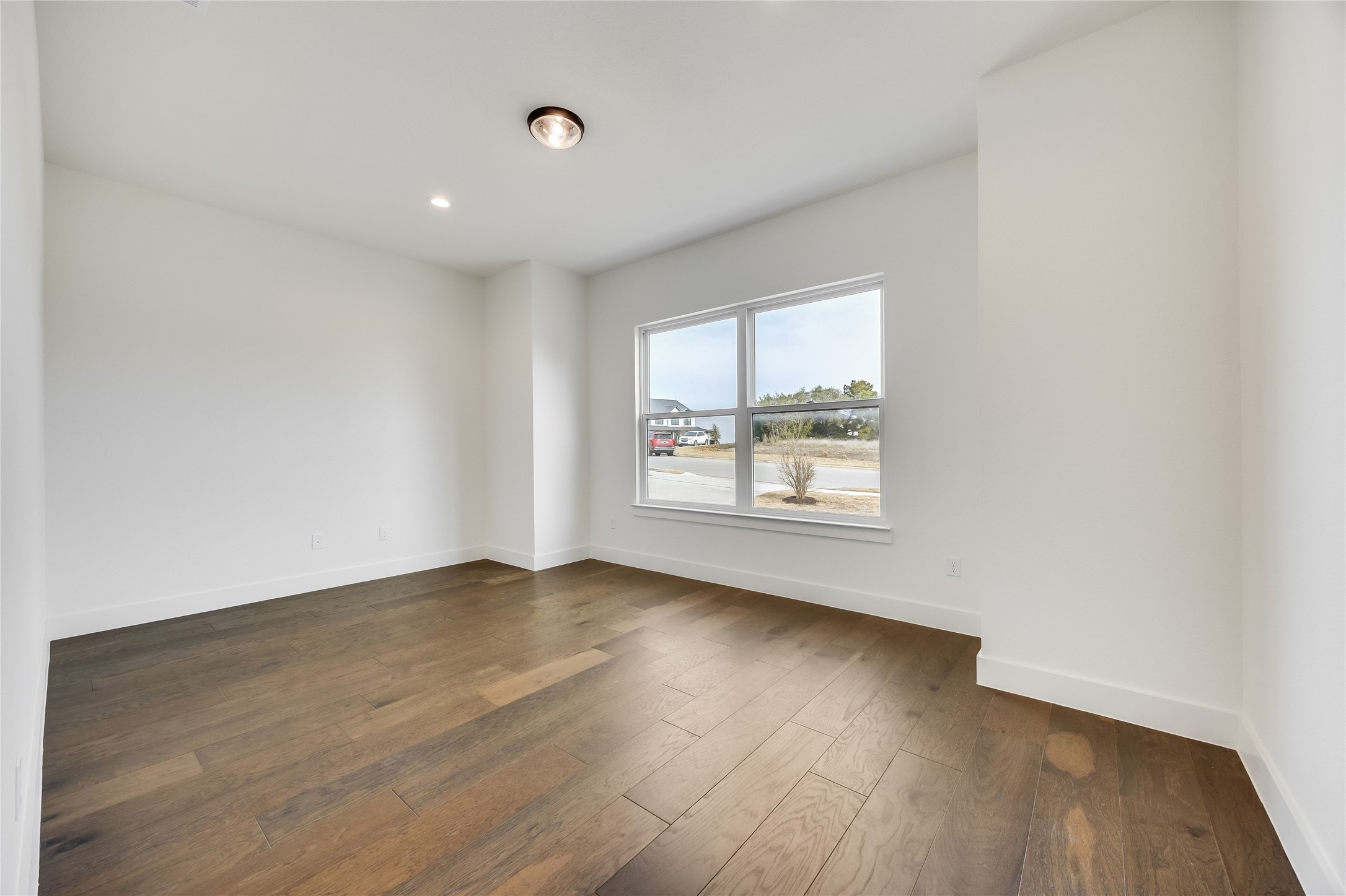 288 Smoke Tree Circle Dripping Springs, TX 78620 - Photo 17 of 40 an empty room with wooden floor and windows