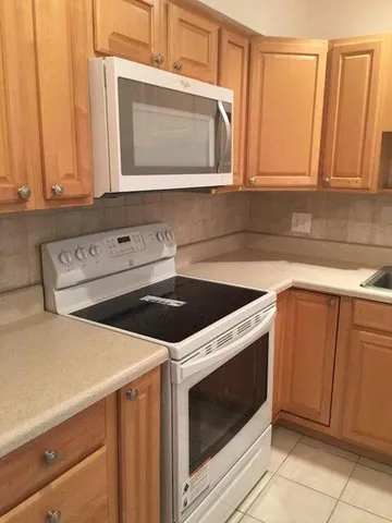 a kitchen with granite countertop cabinets stainless steel appliances and a sink