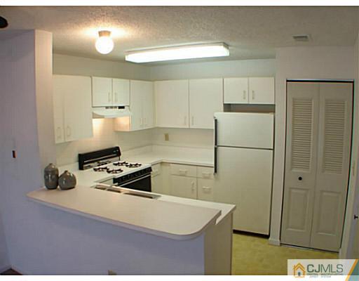 914 Edpas Road New Brunswick, NJ 08901 - Photo 10 of 11 a kitchen with a refrigerator a stove a microwave and cabinets