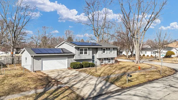 a front view of a house with a yard covered with snow