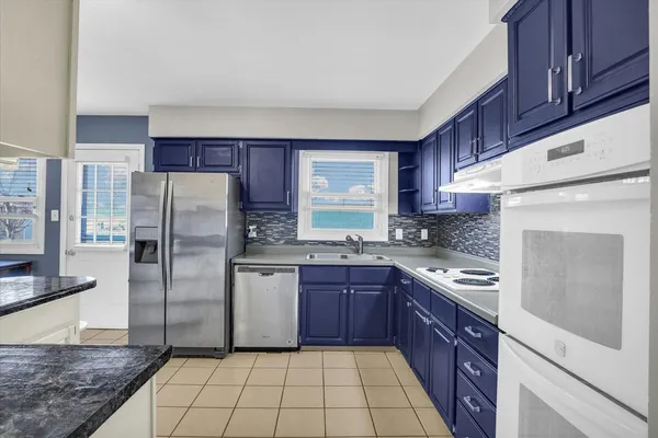 a kitchen with stainless steel appliances granite countertop a refrigerator sink and cabinets
