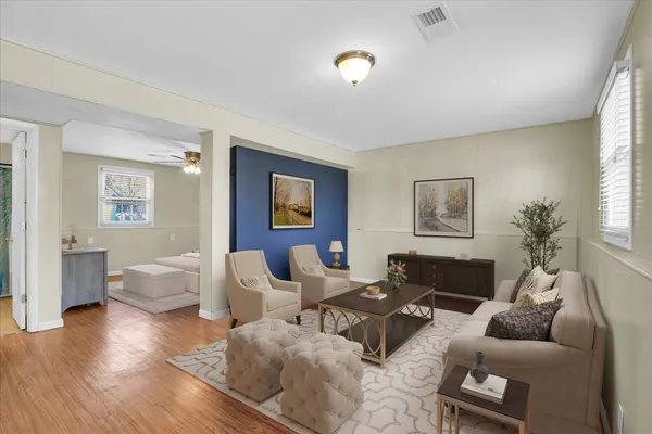 a living room with furniture and a wooden floor