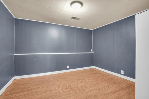 a view of an empty room with wooden floor