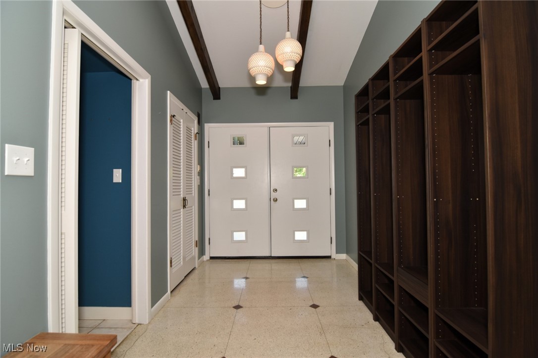 Entryway with tile floor, beam ceiling, and a light fixture