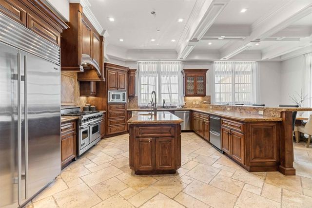 a dining room with wooden floor a chandelier a wooden table and chairs