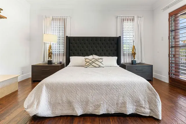 a bedroom with a bed and wooden floor