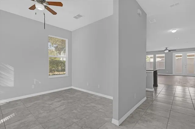 an empty room with windows and fan