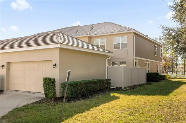 a view of a white house next to a yard