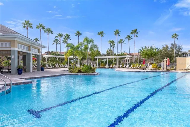 a view of a swimming pool with a chair and tables in the patio