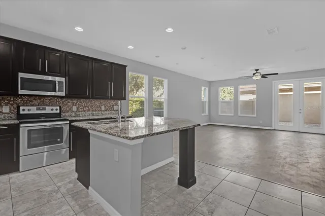 a kitchen with granite countertop a stove and cabinets