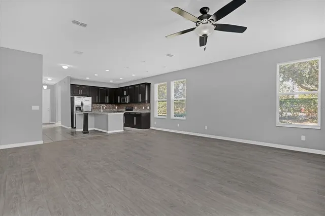 a view of an empty room with a window and a kitchen