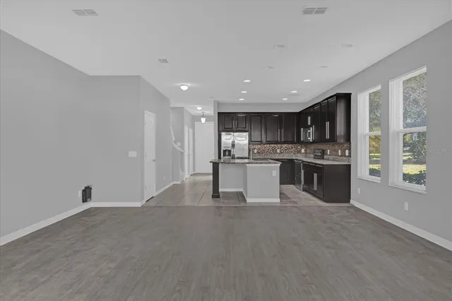 a large white kitchen with stainless steel appliances granite countertop a stove and a sink