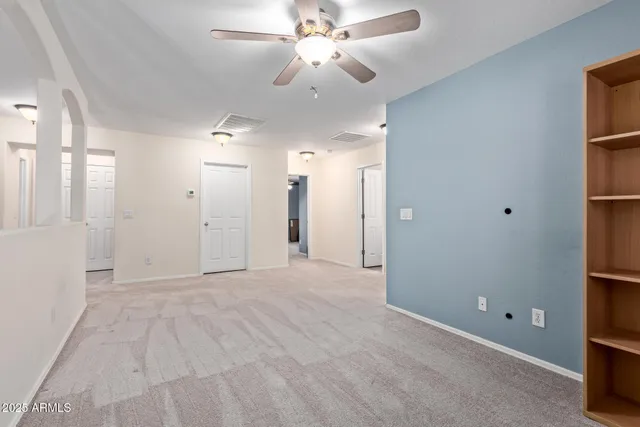 a view of a big room with closet and a ceiling fan