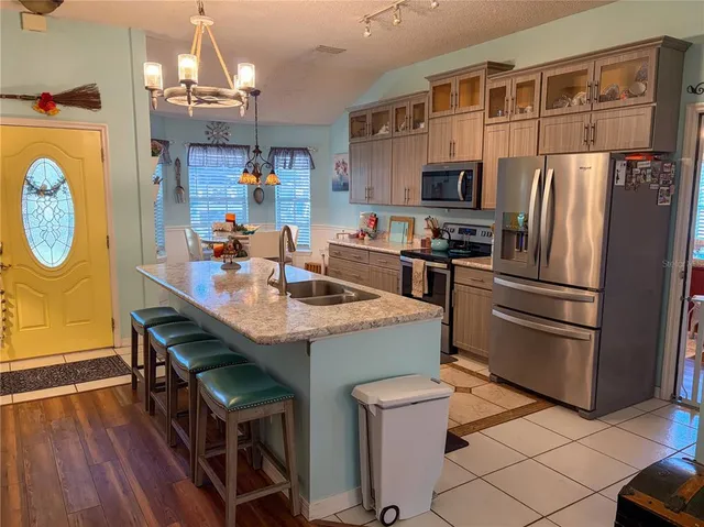 a kitchen with kitchen island a refrigerator stove and microwave