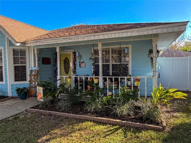 a front view of a house with lots of potted plants