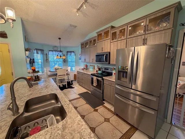 a kitchen with stainless steel appliances granite countertop a refrigerator sink and stove