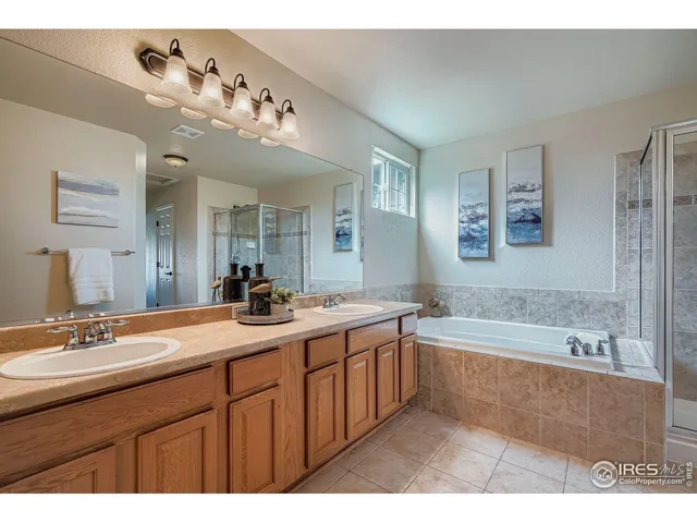 a bathroom with a tub a sink and mirror