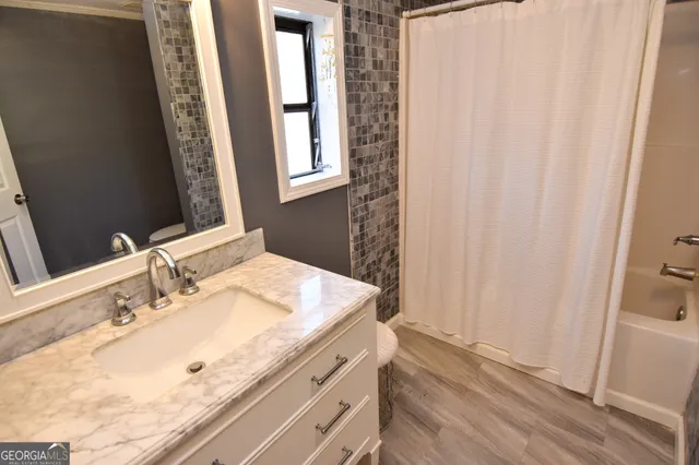 a view of a room with wooden floor windows and a bathroom
