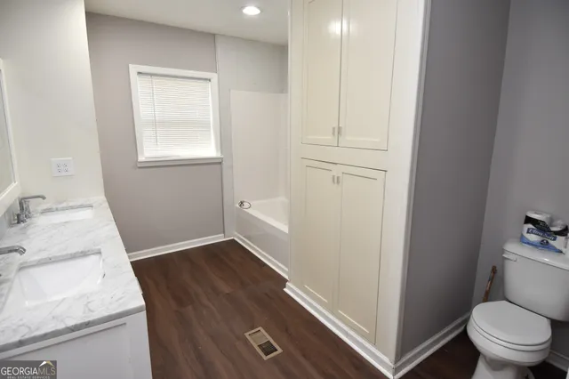 a view of an empty room with wooden floor and windows