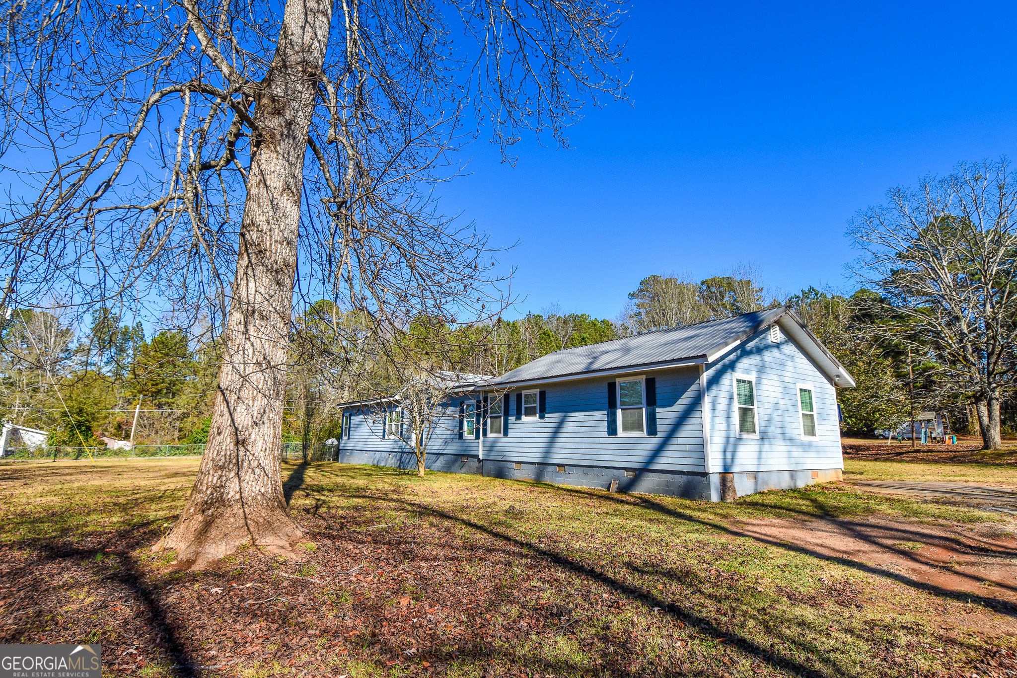 1256 Vaughn Road Griffin, GA 30223 - Photo 4 of 73 a view of a house with large trees and wooden fence