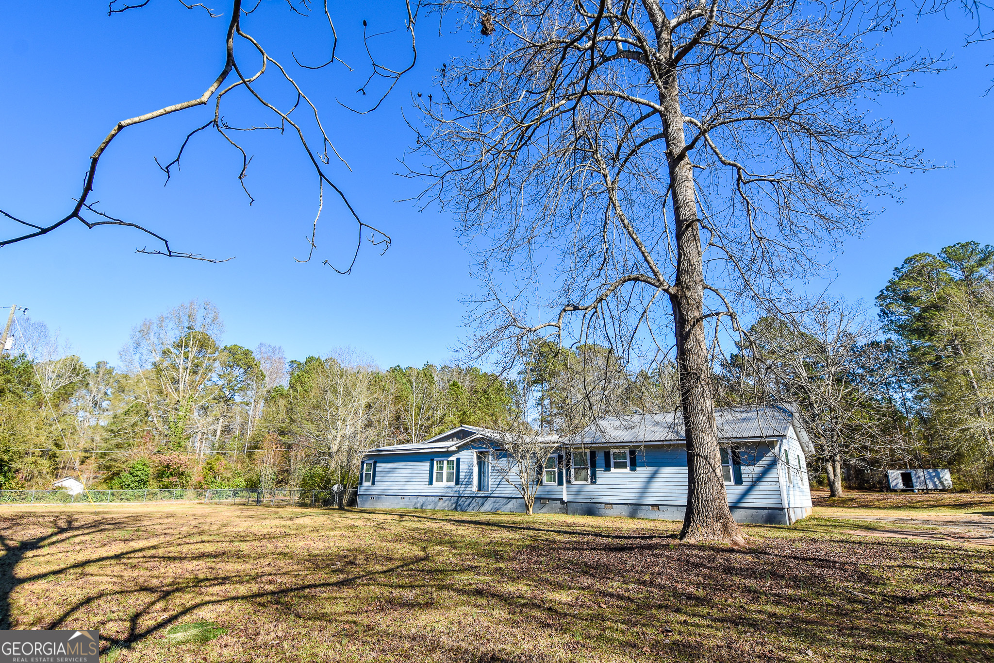 1256 Vaughn Road Griffin, GA 30223 - Photo 6 of 73 a view of a house with large trees and a yard
