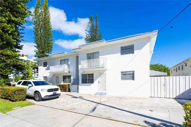 a view of a white car parked in front of a house