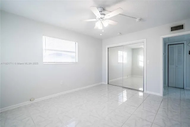 an empty room with fan and windows